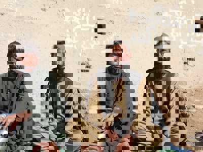 Two men sitting in front of a wall in Helmand Province